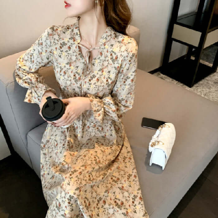 Woman in floral dress sipping coffee, showcasing affordable designer clothing from OnlineHyperMall.
