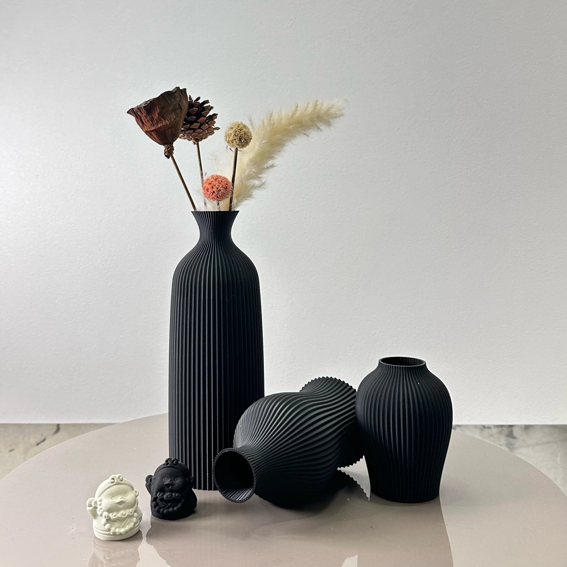 3-Piece Set of Artistic Decorative Vases Elegant Vase in black with dried flowers and ornaments on a table.