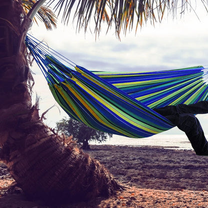 Double Hammock w/Stand, 2-People Hammock & Stand set between palm trees by the beach, colorful blue and green stripes.