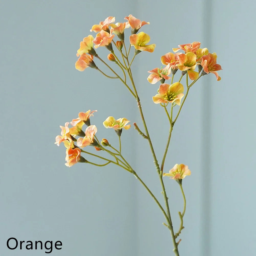 Artificial cornflower decorative flowers in shades of orange with delicate petals and green stems.