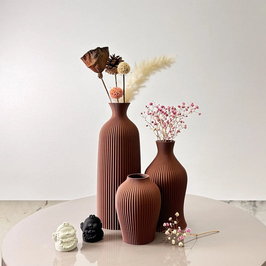 3-Piece Set of Artistic Decorative Vases Elegant Vase with dried flowers and ornaments on a table.